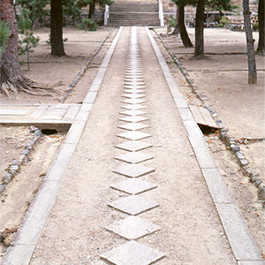 <b>石條（せきじょう）</b>境内に縦横に走っている参道は、正方形の平石を菱形に敷き、両側を石條で挟んだ特殊な形式であり、龍の背の鱗をモチーフ化したものです。